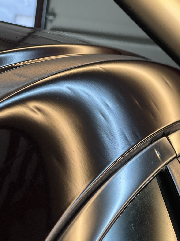 Smooth repaired contour along a dark vehicle roof edge