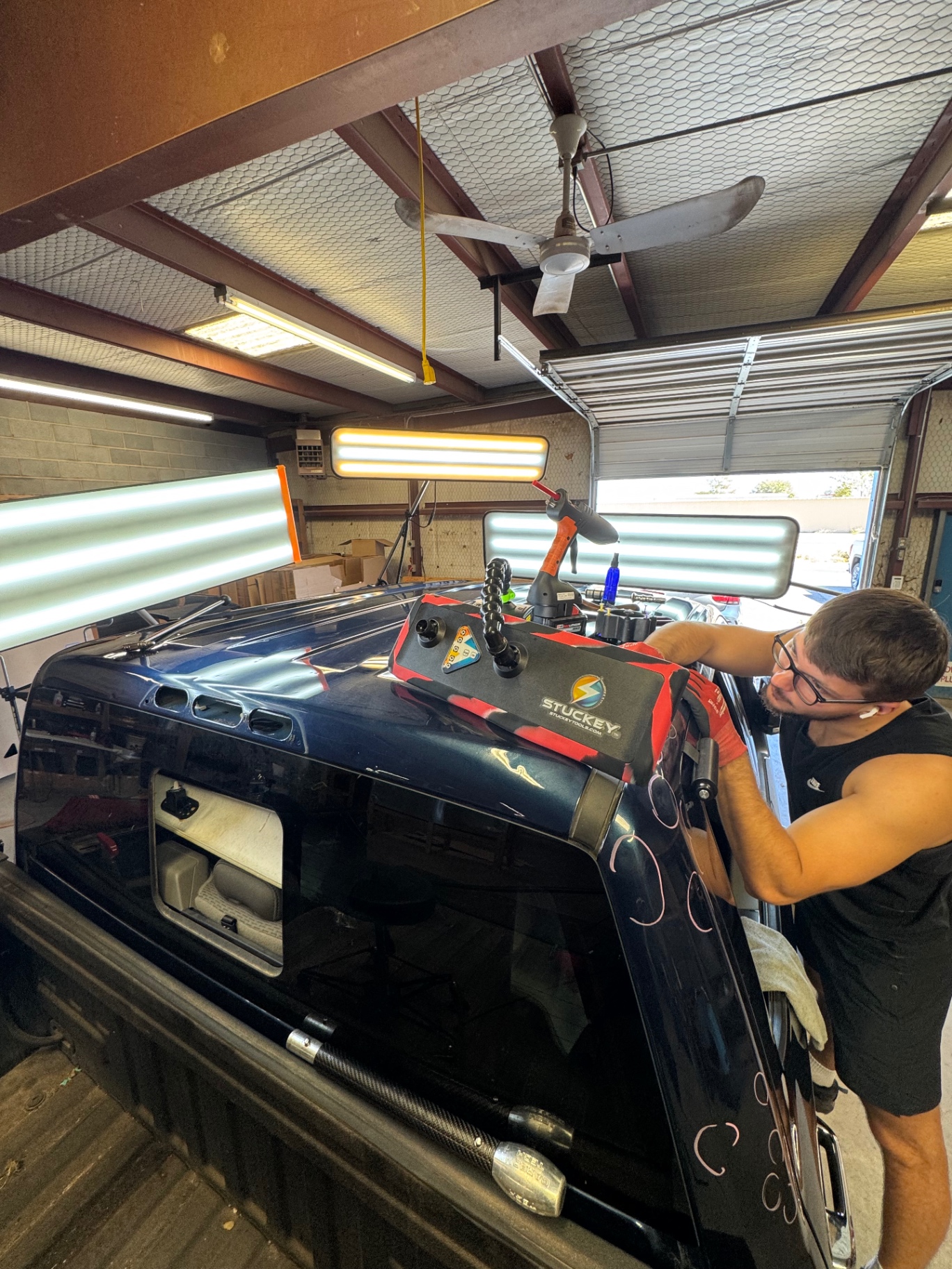 Certified PDR technician removing a dent from a vehicle panel without paint
