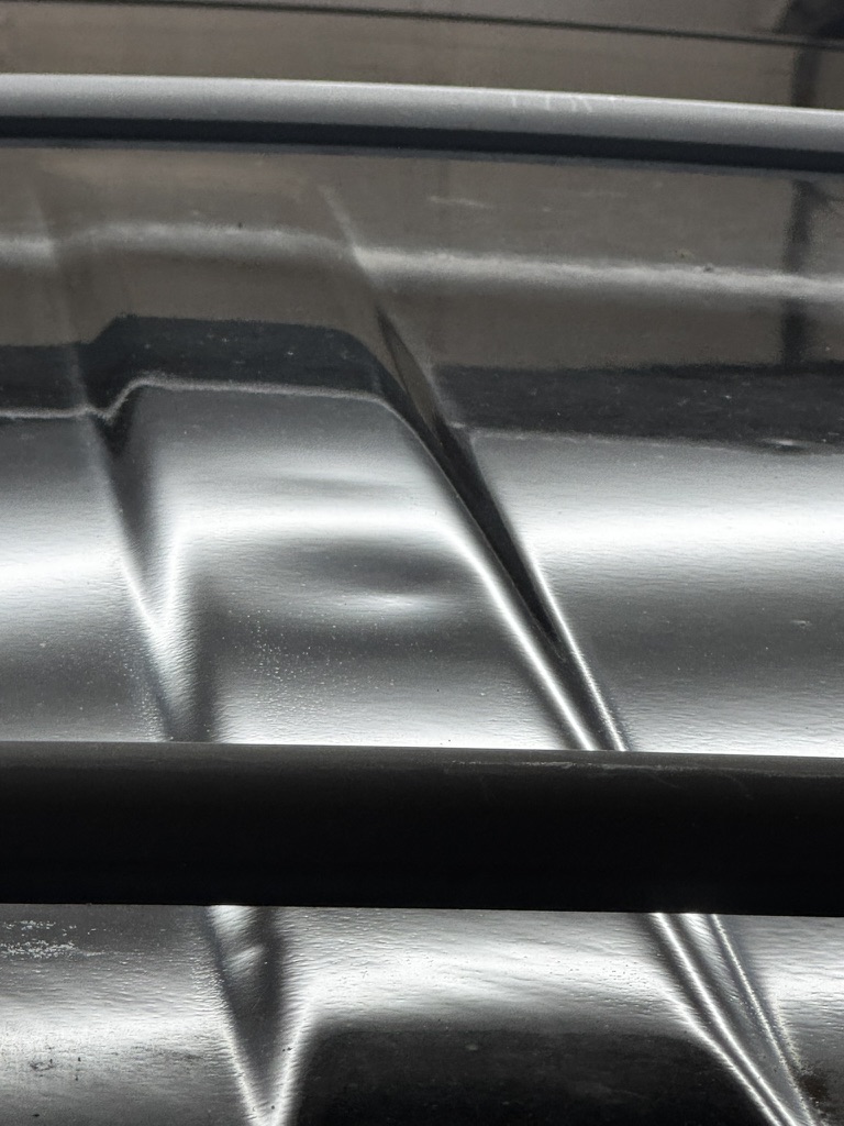 Shallow dent across a raised vehicle body line